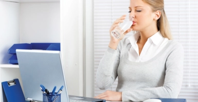 Fontaine entreprise Femme buvant de l'eau dans son bureau